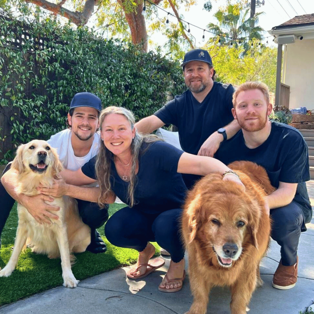 Husband, wife, kids, and dogs in backyard of Los Angeles home