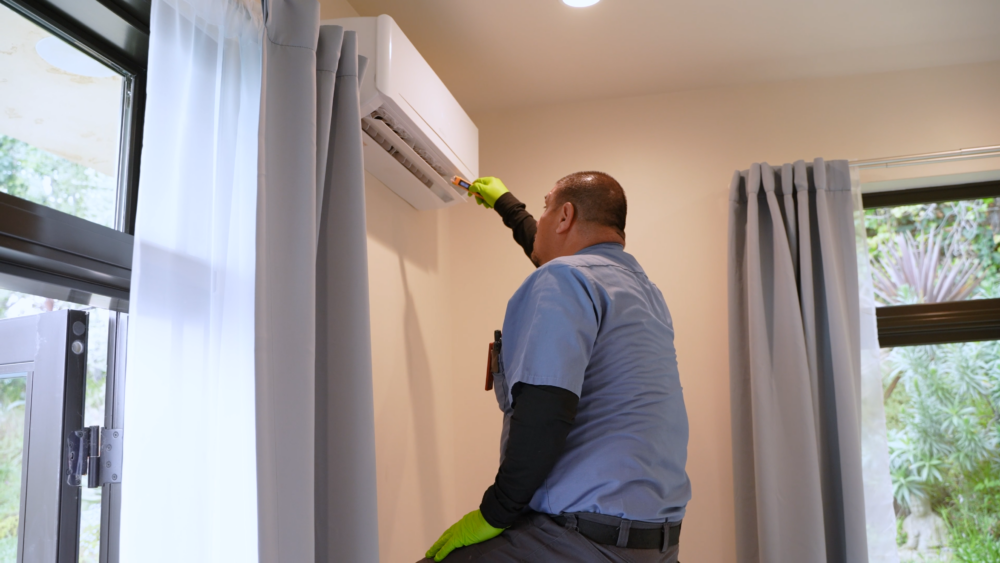 A technician from Monkey Wrench checking the temperature of a mini-split AC system. 