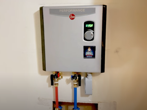 The image shows an electric tankless water heater installed in a home.