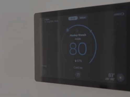 The image shows a smart thermostat from Monkey Wrench.