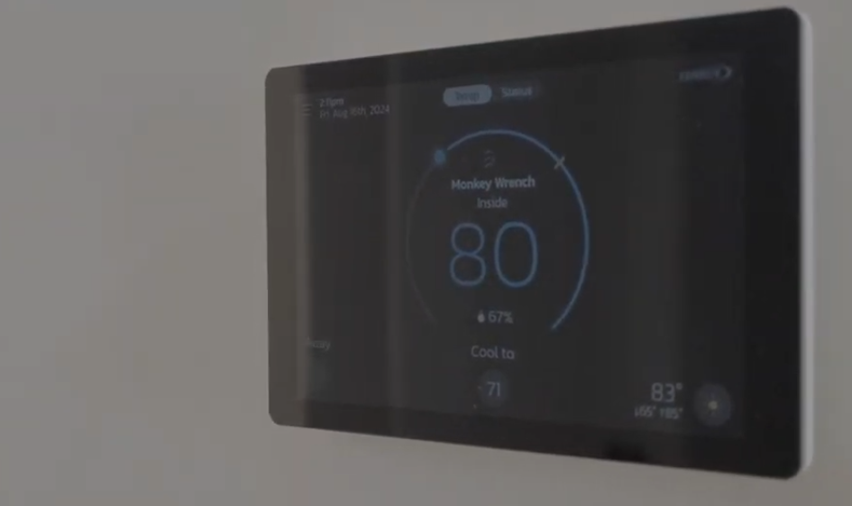 The image shows a smart thermostat from Monkey Wrench.