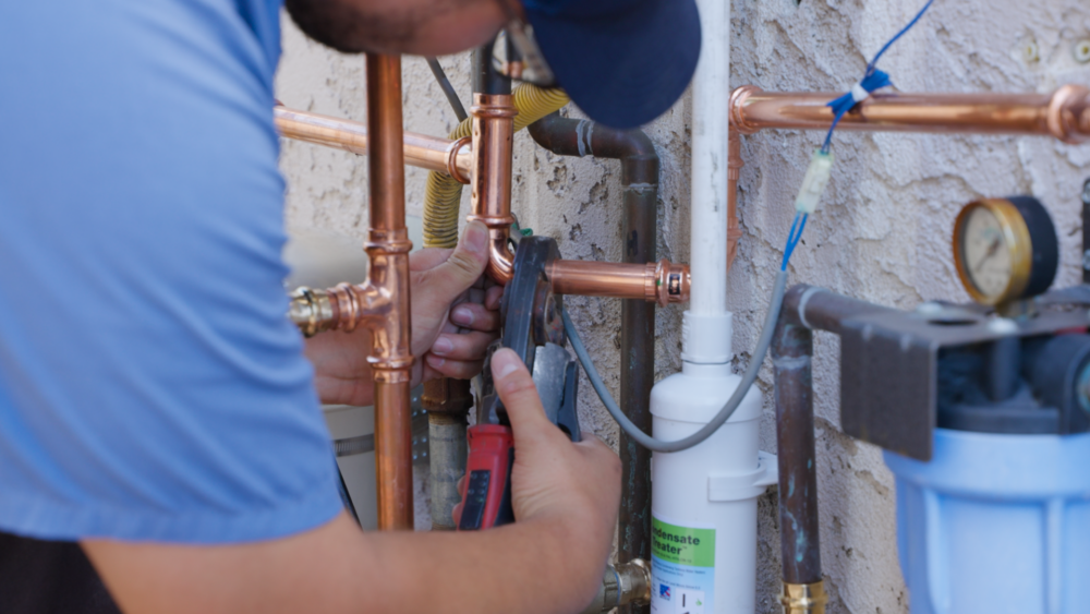 Monkey Wrench technician tightening a copper pipe.