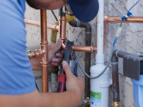 Monkey Wrench technician tightening a copper pipe.