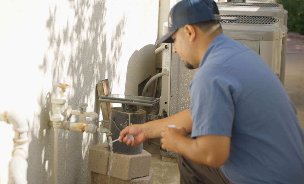 A Monkey Wrench technician running a hard water test strip under a faucet.