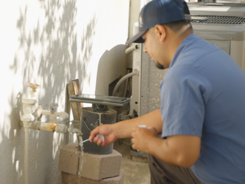 A Monkey Wrench technician running a hard water test strip under a faucet.