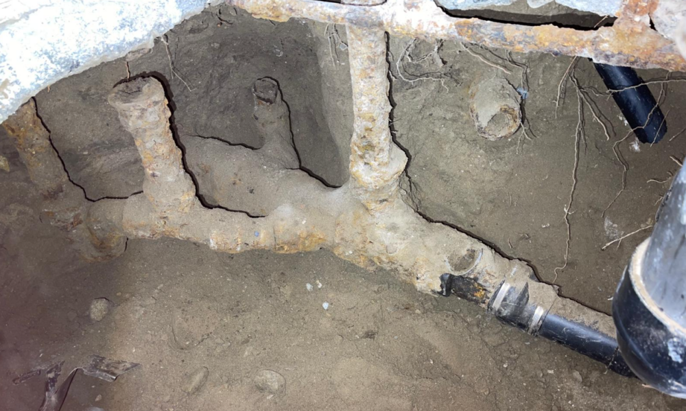 Old, calcified pipes under a home's kitchen.