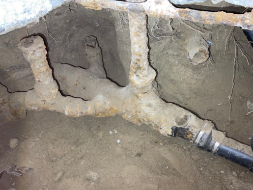 Old, calcified pipes under a home's kitchen.