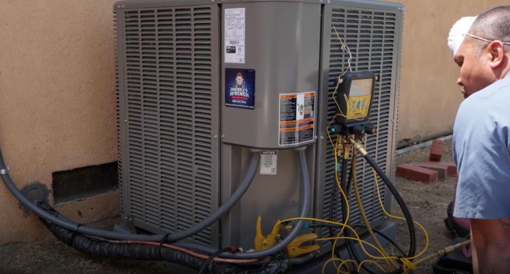 A Monkey Wrench technician is checking the amperage of a outdoor AC unit.