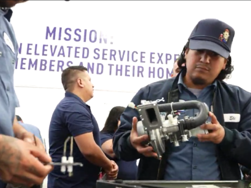 A Monkey Wrench technician inspecting a part pulled from a Rinnai tankless water heater.