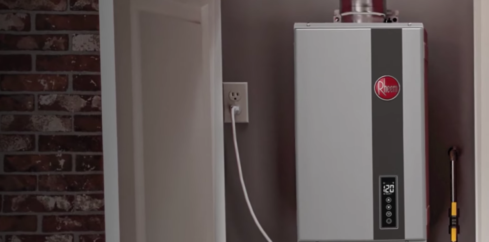 The image shows a Rheem tankless water heater installed inside a home's utility closet. 