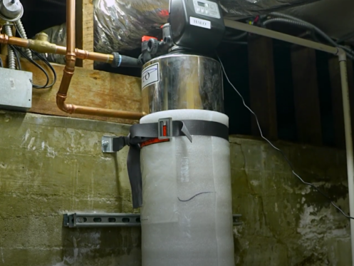 The image shows a water softener installed inside a home.