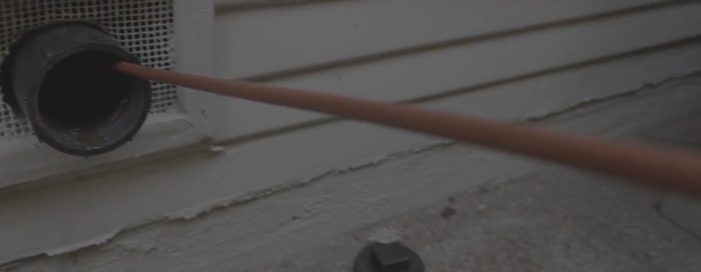 A snake line entering a pipe from outside a home.