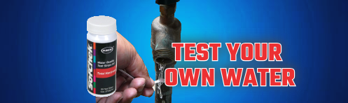 The image shows a water testing kit and a hand holding a water test strip under a faucet.